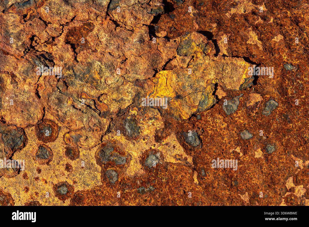 Primo piano di ruggine resistente agli agenti atmosferici con strati di pelatura e patina arancione calda, sfondo industriale dettagliato. Foto Stock