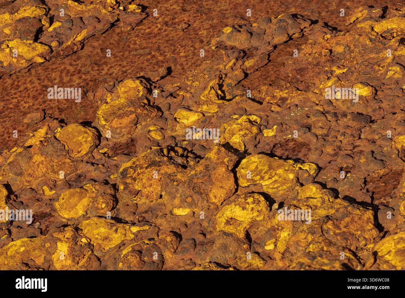 Primo piano di ruggine resistente agli agenti atmosferici con strati di pelatura e patina arancione calda, sfondo industriale dettagliato. Foto Stock