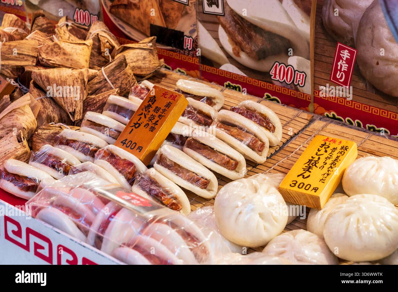Selezione di vari piatti caldi cinesi su vassoi su una bancarella a Chinatown, Kobe. Panini al vapore e gnocchi di maiale al vapore, con blocchi di legno. Foto Stock