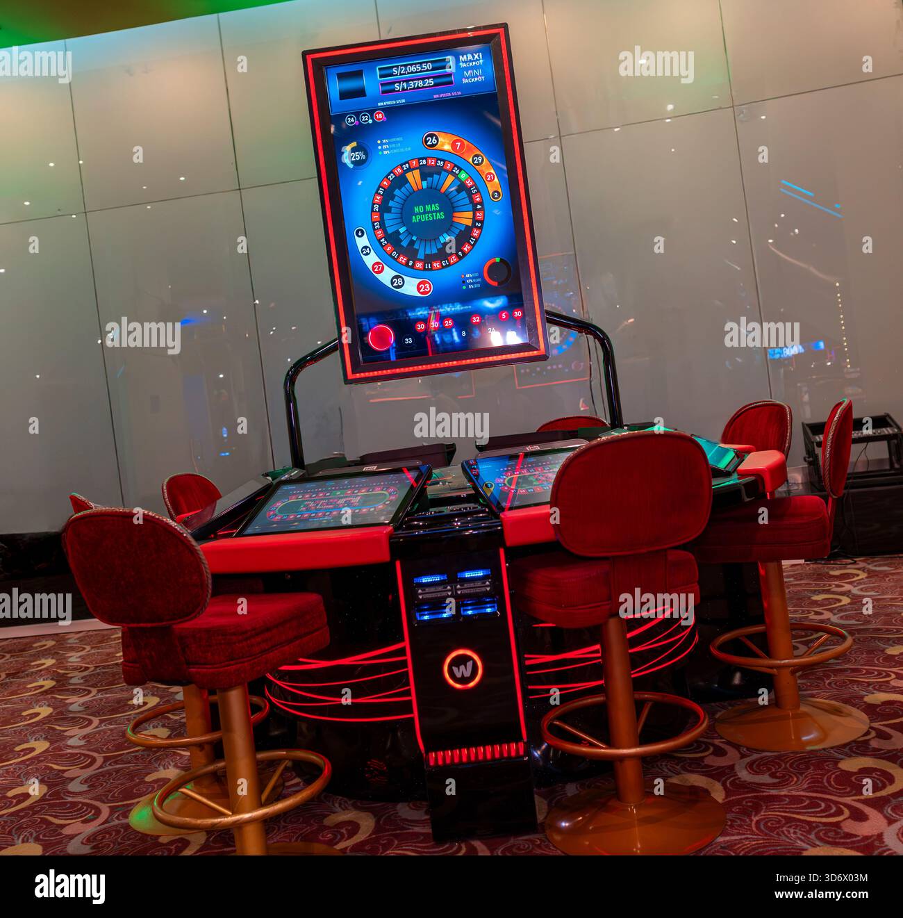 Roulette elettronica con display digitale e sedie da gioco rosse all'interno di un moderno ambiente da casinò, che mostra tecnologia e configurazione delle scommesse. Foto Stock