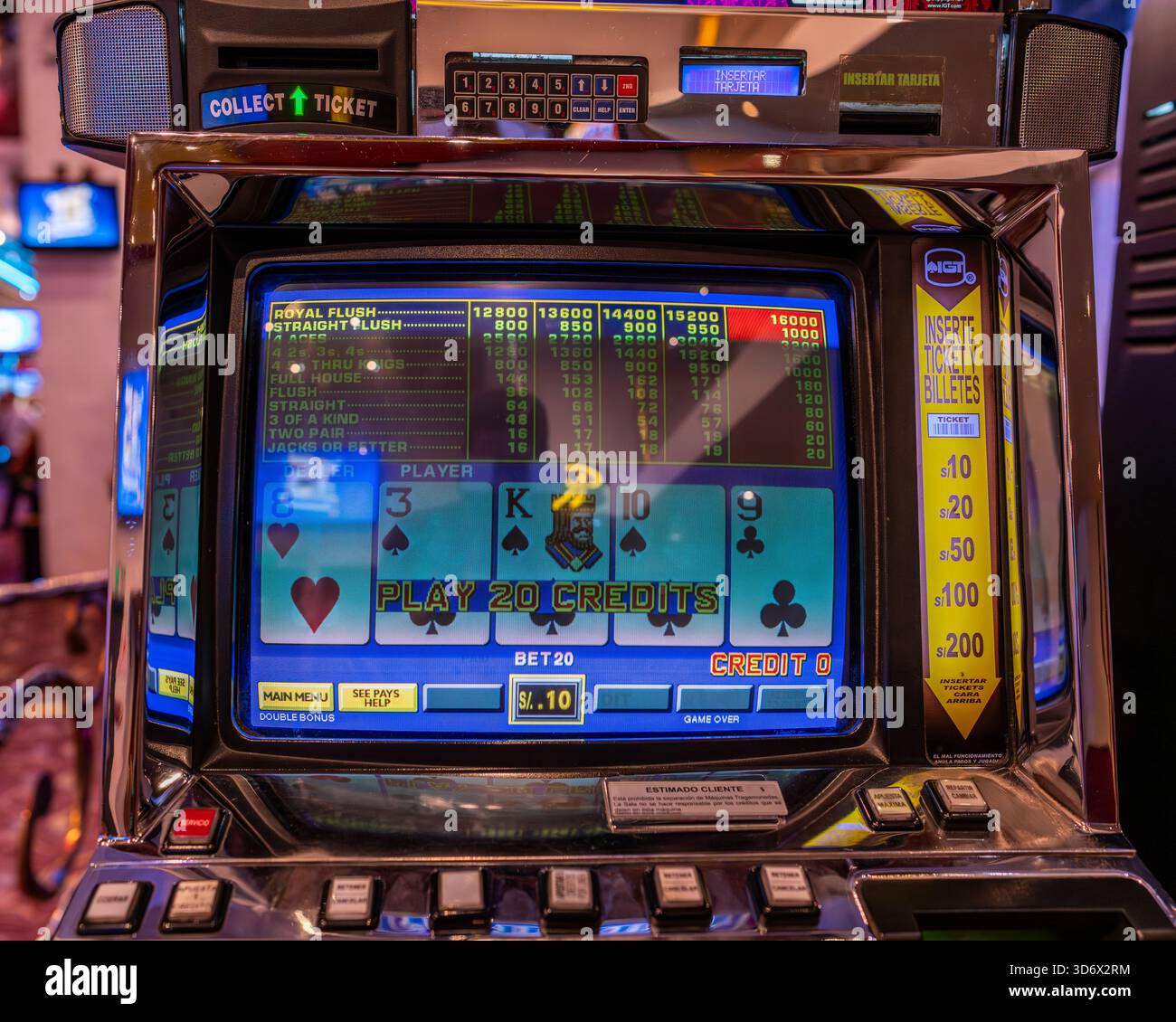 Primo piano dello schermo di una macchina da poker video che mostra carte, tavolo dei pagamenti, pulsanti e dettagli illuminati di gioco all'interno di un casinò. Foto Stock