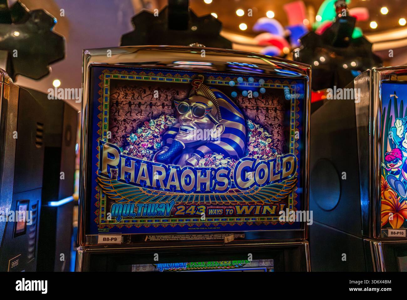 Slot machine Gold di Pharaoh colorata con grafica a tema egiziano all'interno di un ambiente di gioco moderno e vivace. Foto Stock
