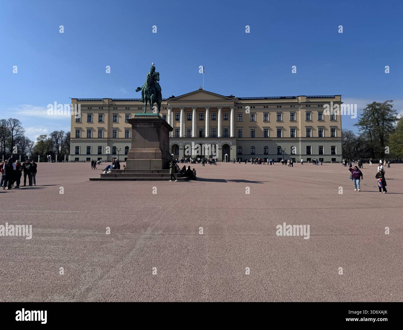 Il Palazzo reale si erge su un'ampia piazza aperta, con i visitatori che camminano sotto un cielo azzurro. - Immagine stock catturata con smartphone