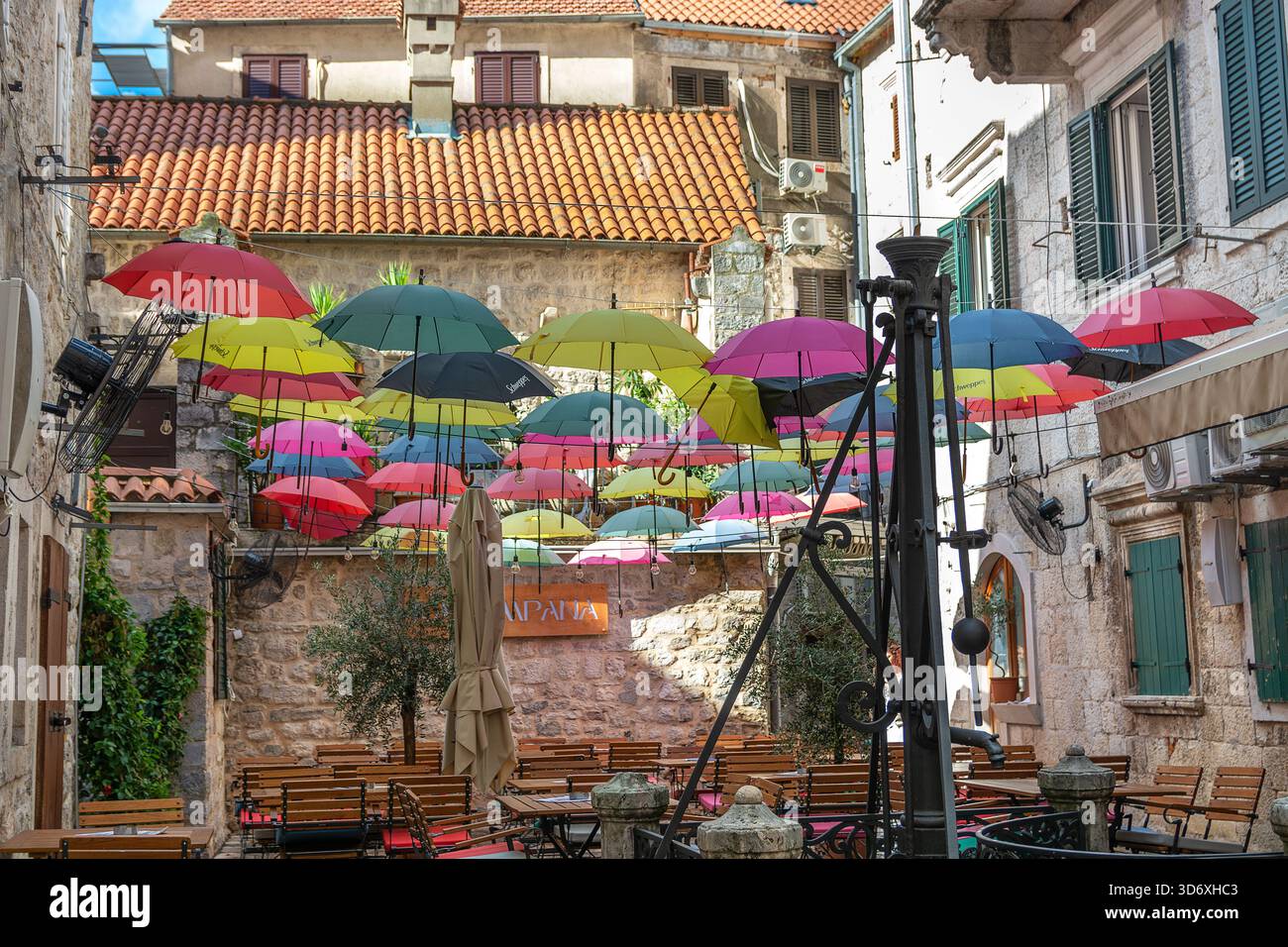 Un colorato ombrello all'esterno di una caffetteria nella città vecchia di Cattaro, che annuncia la stagione delle piogge che arriva a novembre Foto Stock