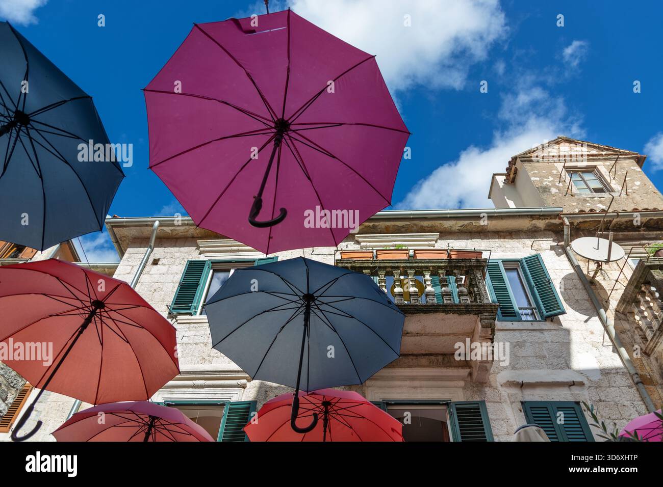Un colorato ombrello all'esterno di una caffetteria nella città vecchia di Cattaro, che annuncia la stagione delle piogge che arriva a novembre Foto Stock