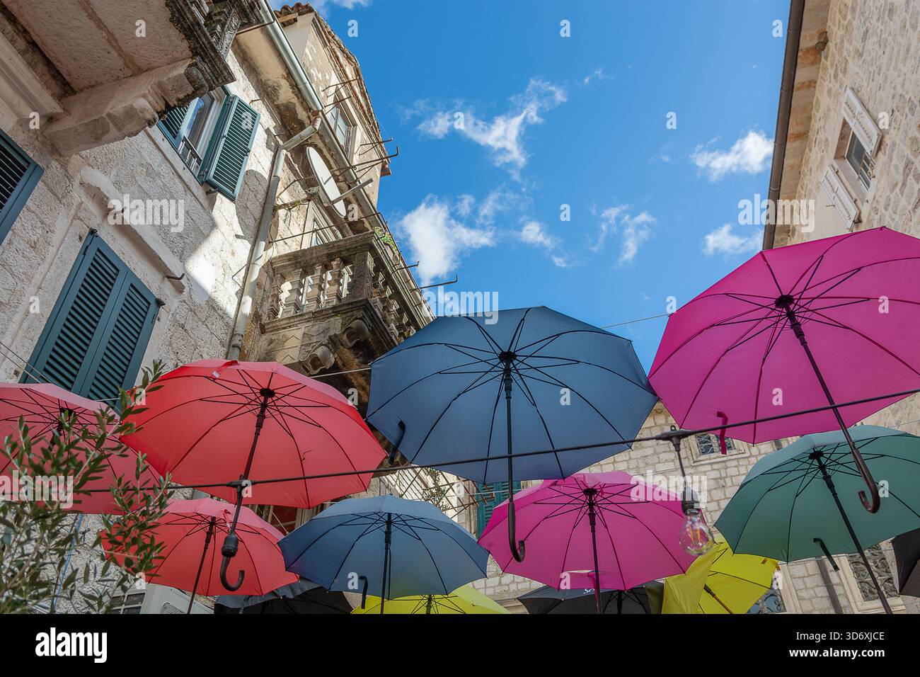 Un colorato ombrello all'esterno di una caffetteria nella città vecchia di Cattaro, che annuncia la stagione delle piogge che arriva a novembre Foto Stock