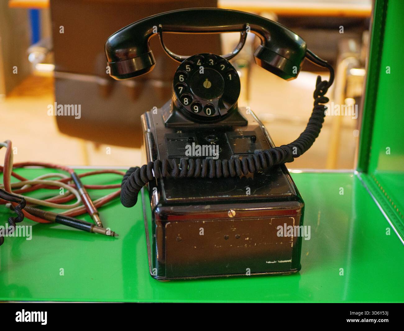 Un telefono con manopola retrò posizionato su un tavolo. Il dispositivo mette in risalto le classiche apparecchiature di comunicazione dei decenni precedenti. Foto Stock