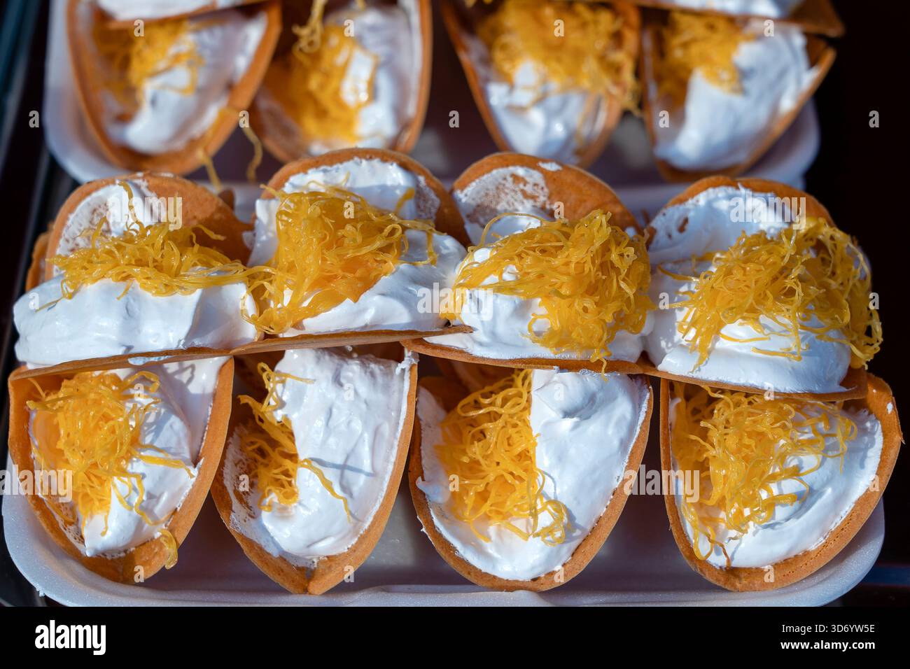 Deliziosa strada Thai dessert, Kanom Buang, Tailandese frittelle croccanti o Thai crêpe con varietà di farciture come bianco e dolce crema pasticcera e golden Foto Stock