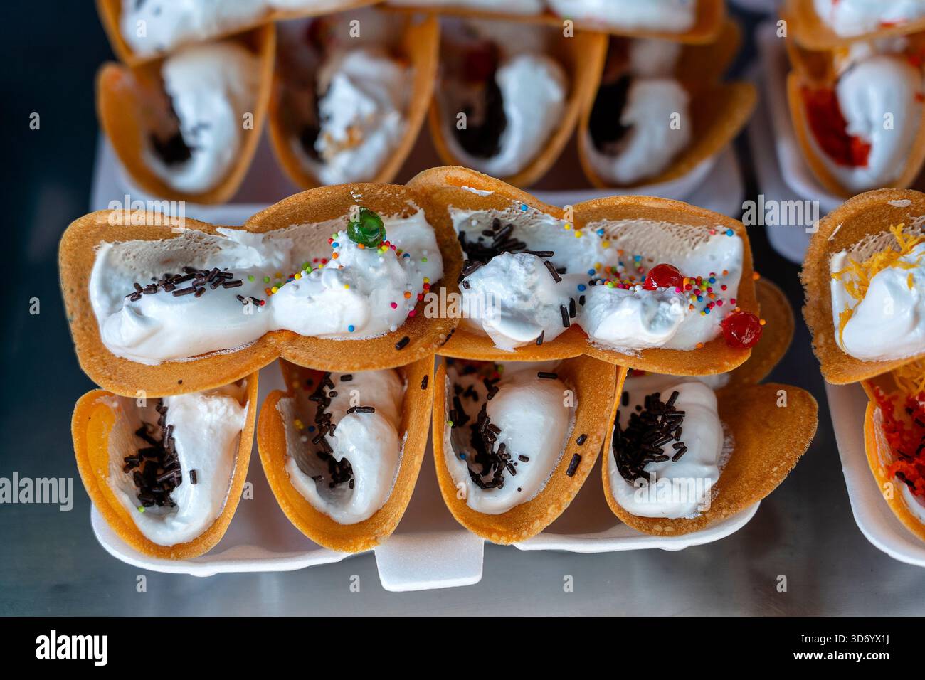Deliziosa strada Thai dessert, Kanom Buang, Tailandese frittelle croccanti o Thai crêpe con varietà di farciture come bianco e dolce crema pasticcera e golden Foto Stock