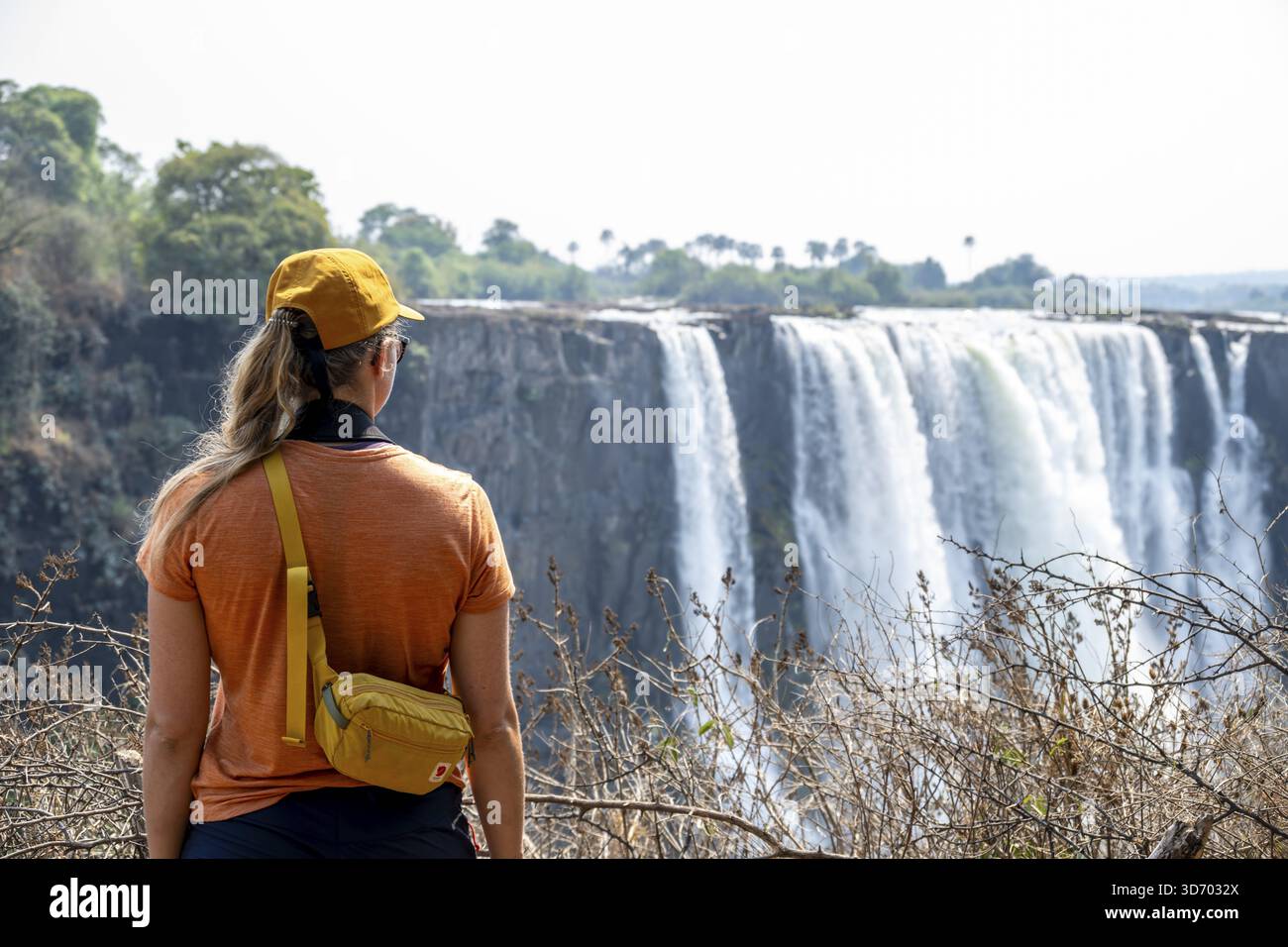 Turisti che guardano le cascate, le acque che si tuffano nelle profondità, le Cascate Vittoria, lo Zimbabwe Foto Stock