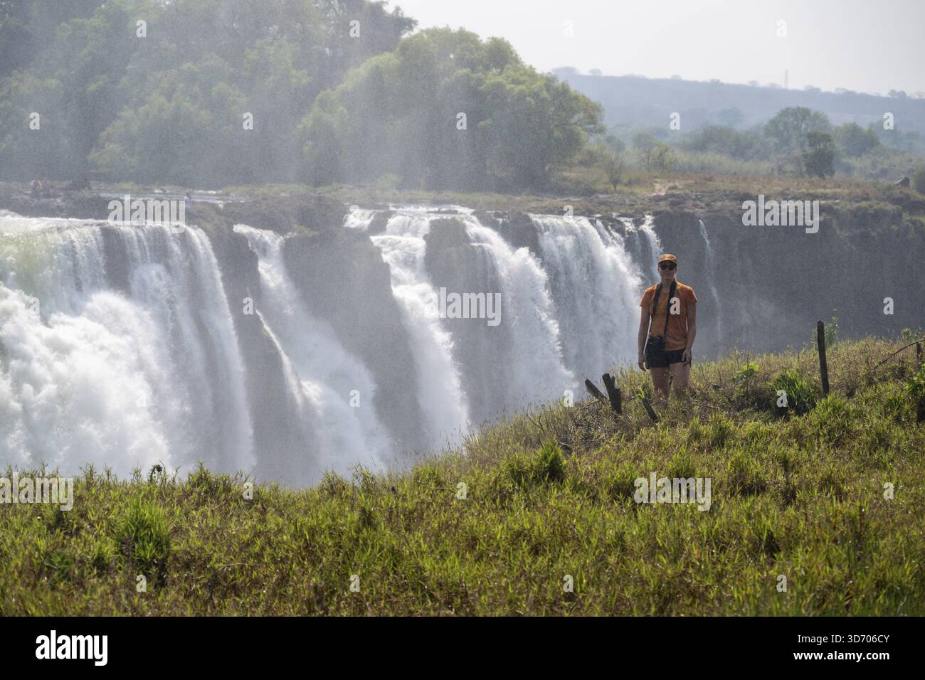 Turisti che guardano le cascate, le acque che si tuffano nelle profondità, le Cascate Vittoria, lo Zimbabwe Foto Stock