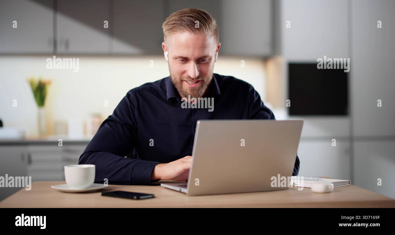 Uomini che partecipano a una sessione di formazione virtuale su un notebook in cucina Foto Stock