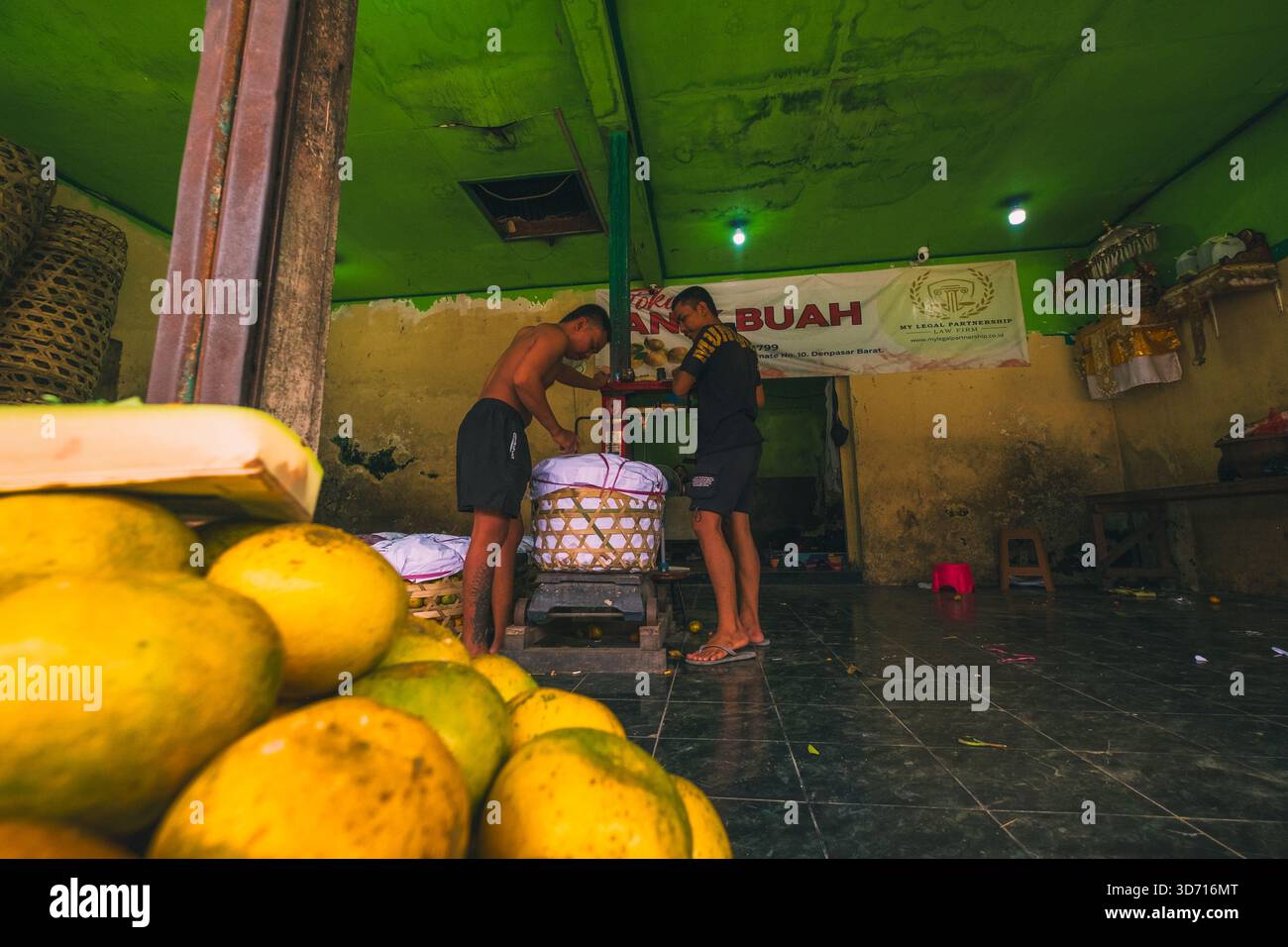 I commercianti di frutta pesano i loro frutti al Badung Market, 27 settembre 2025, Bali, Indonesia. Foto Stock