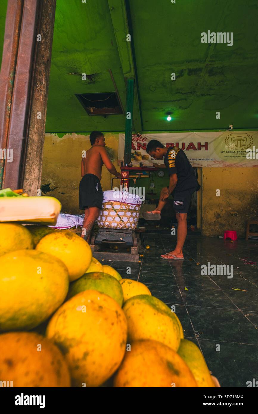 I commercianti di frutta pesano i loro frutti al Badung Market, 27 settembre 2025, Bali, Indonesia. Foto Stock