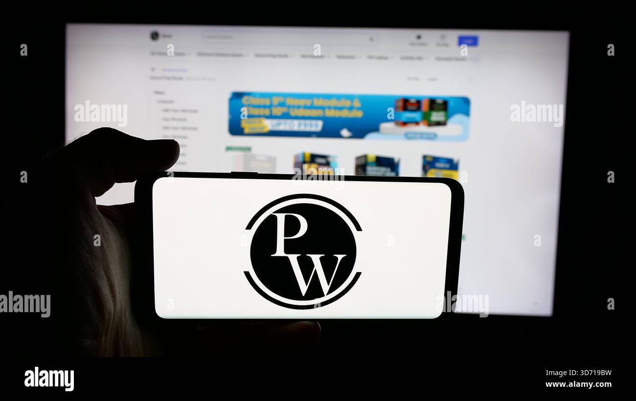 In questa illustrazione fotografica, una persona ha in mano un cellulare con il logo della società indiana Physics Wallah Limited (PW) sullo schermo davanti alla pagina web. Foto Stock