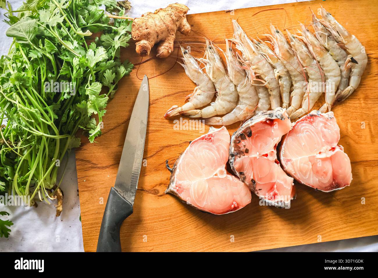 Assortimento di pesce. Gamberetti freschi e pezzetti di pesce su una tavola di legno. Cibo crudo, gamberi e pesce. Foto Stock