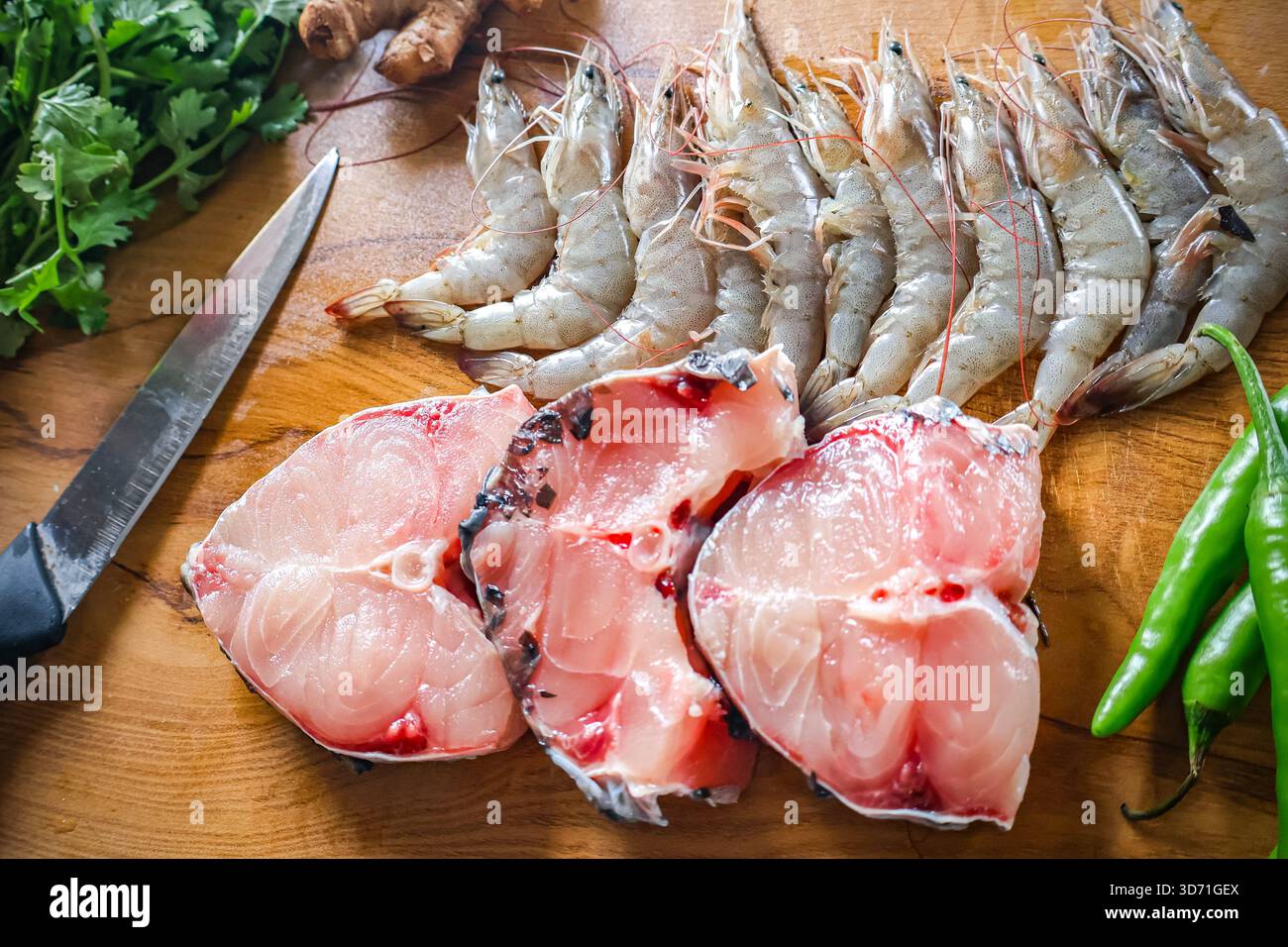 Assortimento di pesce. Gamberetti freschi e pezzetti di pesce su una tavola di legno. Cibo crudo, gamberi e pesce. Foto Stock