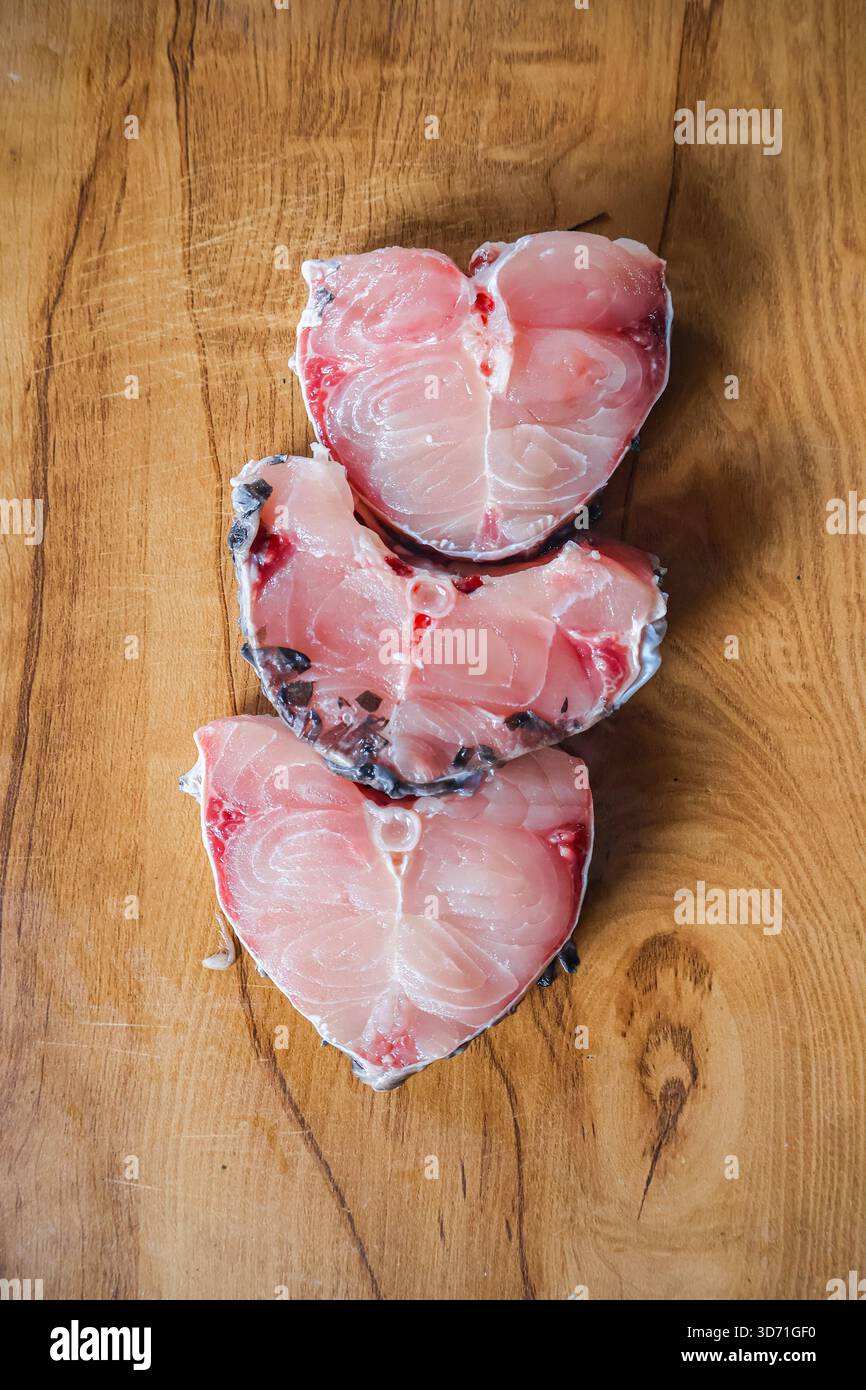 Fette di pesce su un tavolo di legno. Aringhe di pesce, pezzetti di pesce sani e freschi. Foto Stock