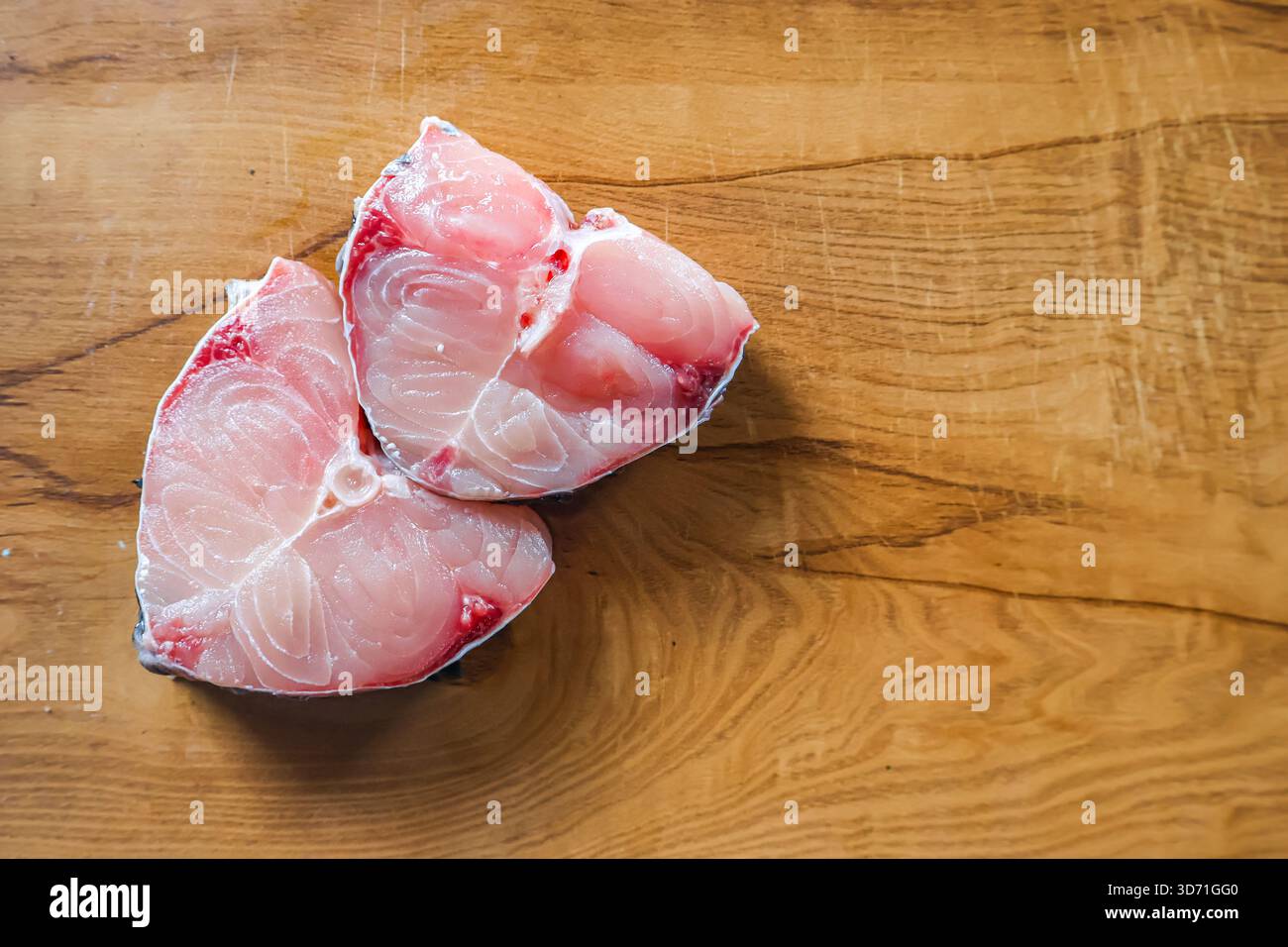 Fette di pesce su un tavolo di legno. Aringhe di pesce, pezzetti di pesce sani e freschi. Foto Stock