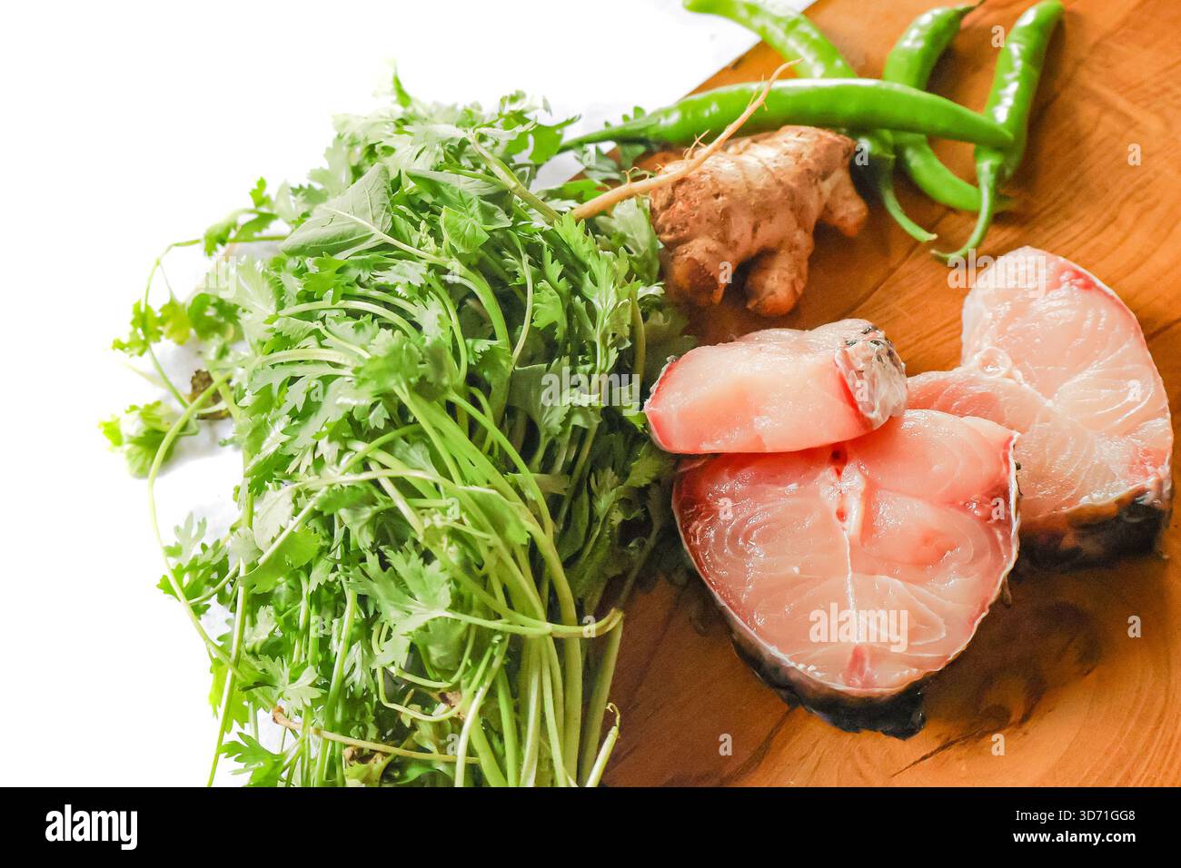 Pesce pronto per cucinare. Pezzetti di pesce fresco su una tavola di legno. Pesce crudo e verdure. Foto Stock