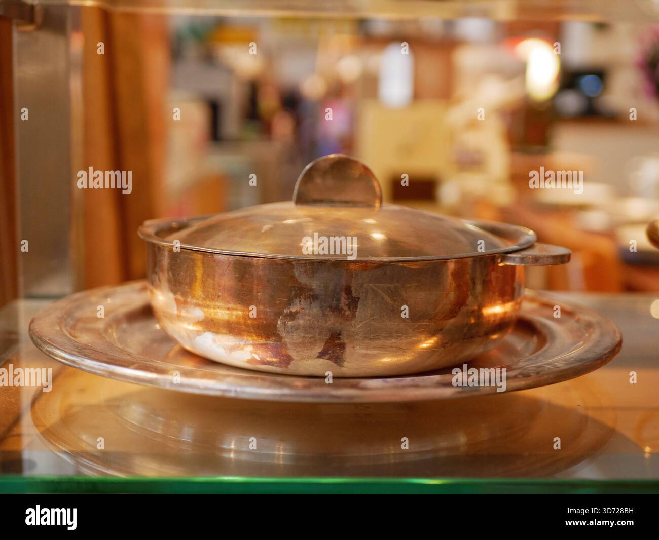 Pentola di cottura in rame con coperchio sul bancone della cucina, superficie in metallo rosso-rame lucido, pentole dal design classico per uso culinario, attrezzature da cucina Foto Stock