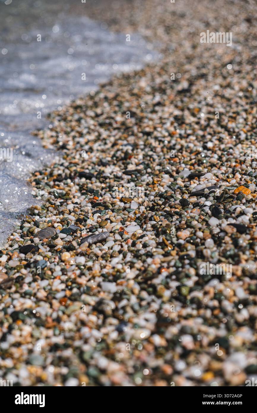 primo piano delle onde oceaniche che si infrangono su una spiaggia di ciottoli Foto Stock