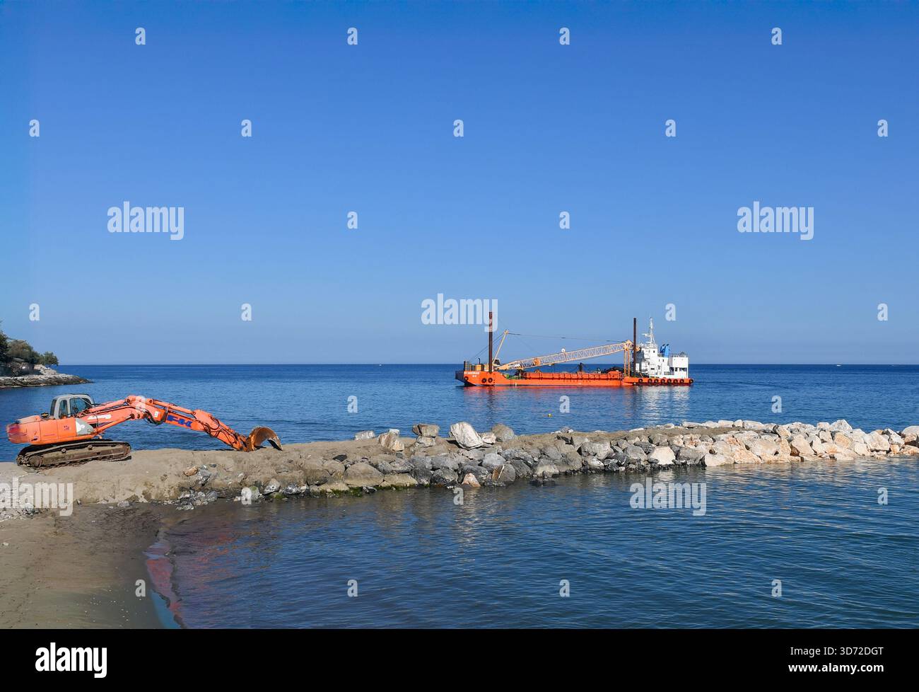 Vista rialzata della spiaggia con un escavatore e una chiatta con gru che trasporta rocce per il restauro della costa, Alassio (Savona), Liguria, Italia Foto Stock