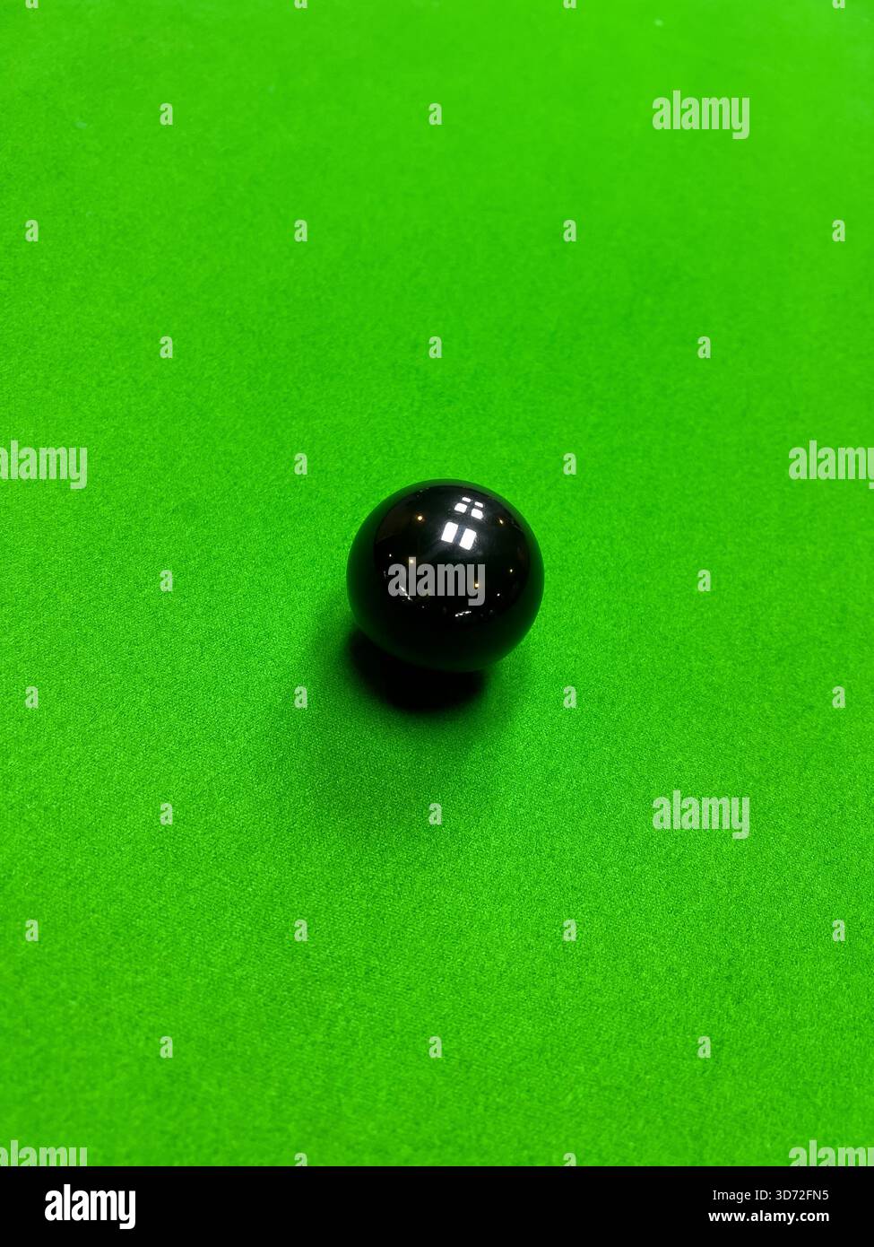 Un tiro ad angolo alto di una singola palla da snooker nera in corso. Foto Stock