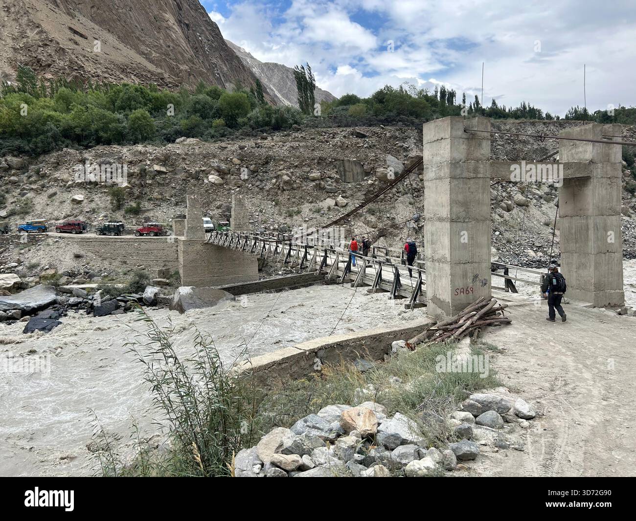 Un viaggio in jeep da Skardu ad Askole coinvolge strade e ponti notoriamente stretti. Il fiume è il Bradlu e l'acqua alla fine raggiungerà l'Indo. Foto Stock