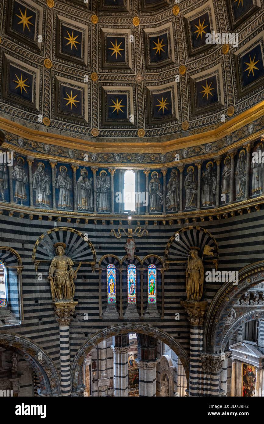 Siena, Italia - 19 luglio 2025: All'interno della Cattedrale di Siena, Italia: Impressionanti colonne in marmo bianco e nero, pavimento decorato a mosaico, cupola illuminata dalle stelle. Foto Stock
