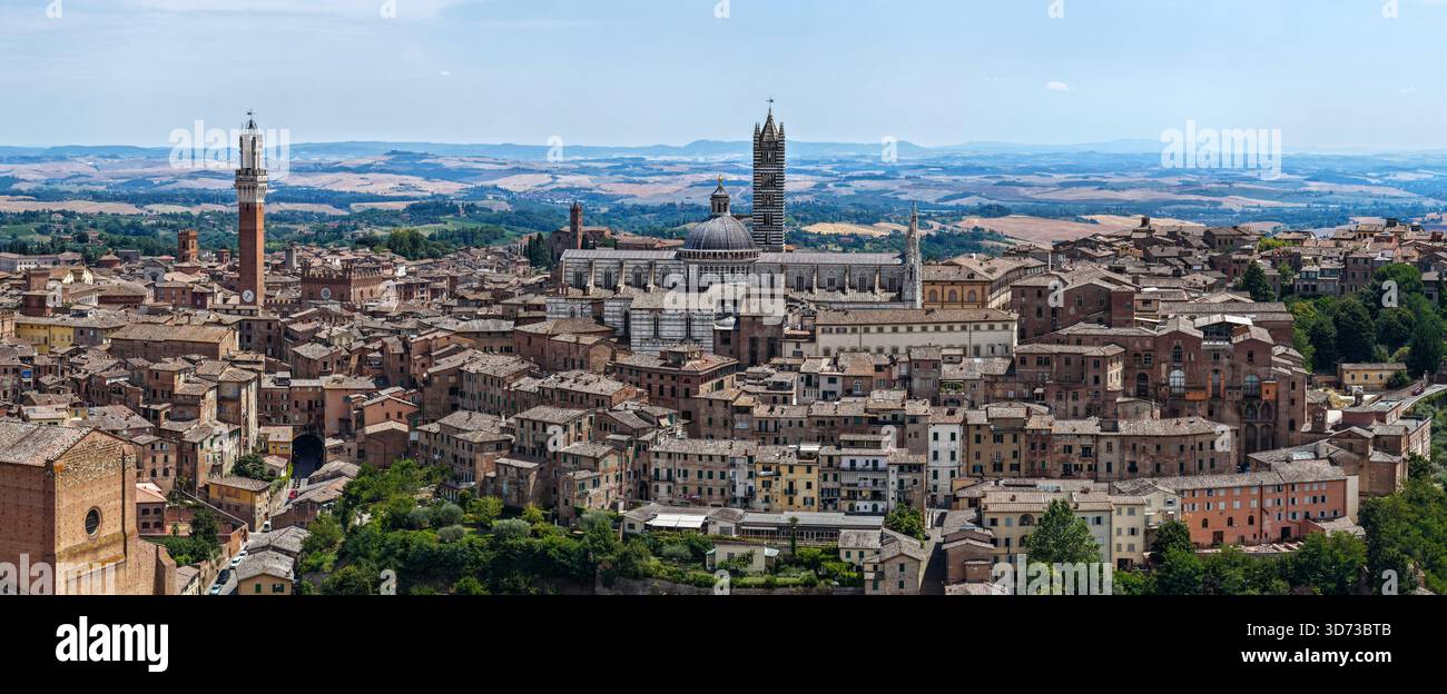 La Cattedrale di Siena, un capolavoro dell'architettura gotica italiana, domina lo skyline con l'esterno in marmo a righe e l'intricata facciata. Visto qui Foto Stock