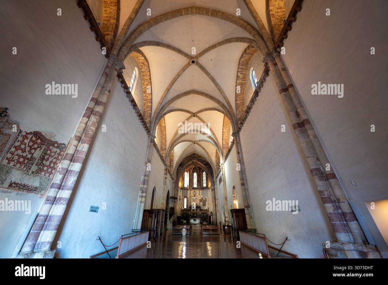 Assisi, Italia - 18 luglio 2025: Interni gotici con volte a costine e archi in pietra pallida nella Basilica di Santa chiara, Assisi. Presenta colorazione complessa Foto Stock