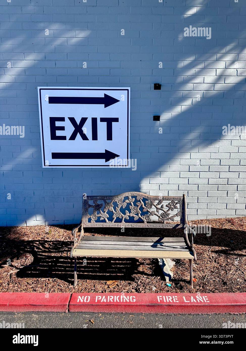 Cartello di uscita sulla parete in mattoni sopra il banco decorativo - Immagine stock catturata con smartphone