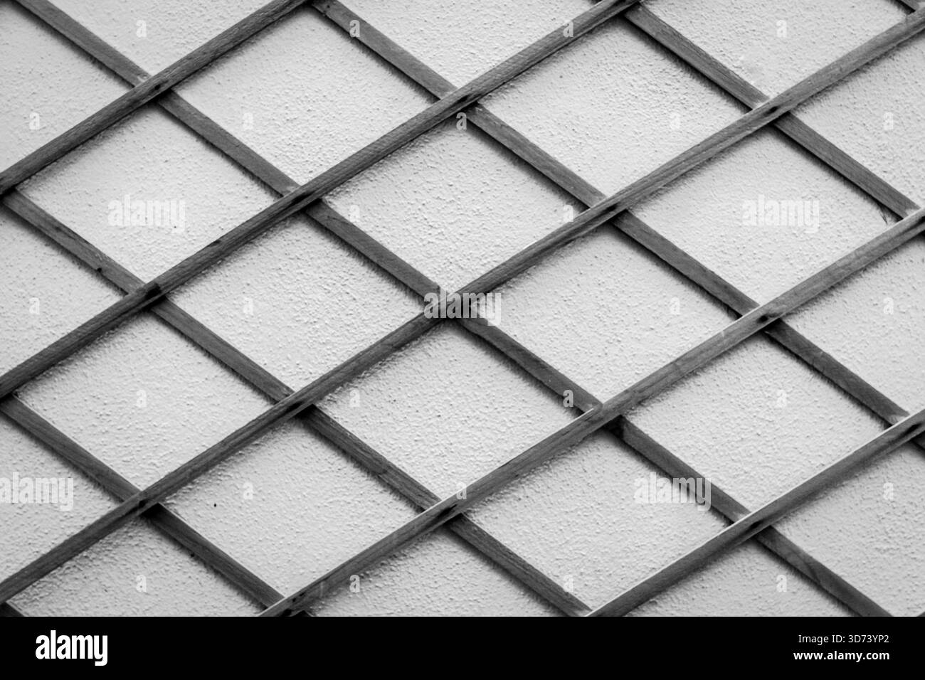 Motivo recinzione in bianco e nero di lattice su muratura testurizzata per sfondi astratti Foto Stock