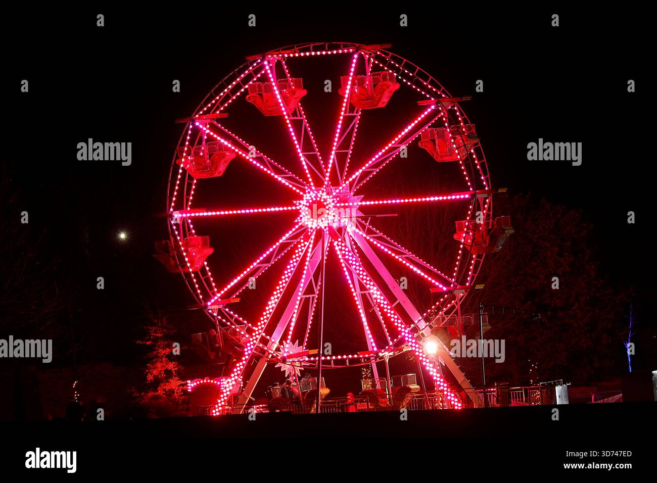 Lunga esposizione di una ruota panoramica illuminata di notte durante l'evento dell'aurora boreale al Temple Newsam di Leeds, West Yorkshire, Regno Unito Foto Stock