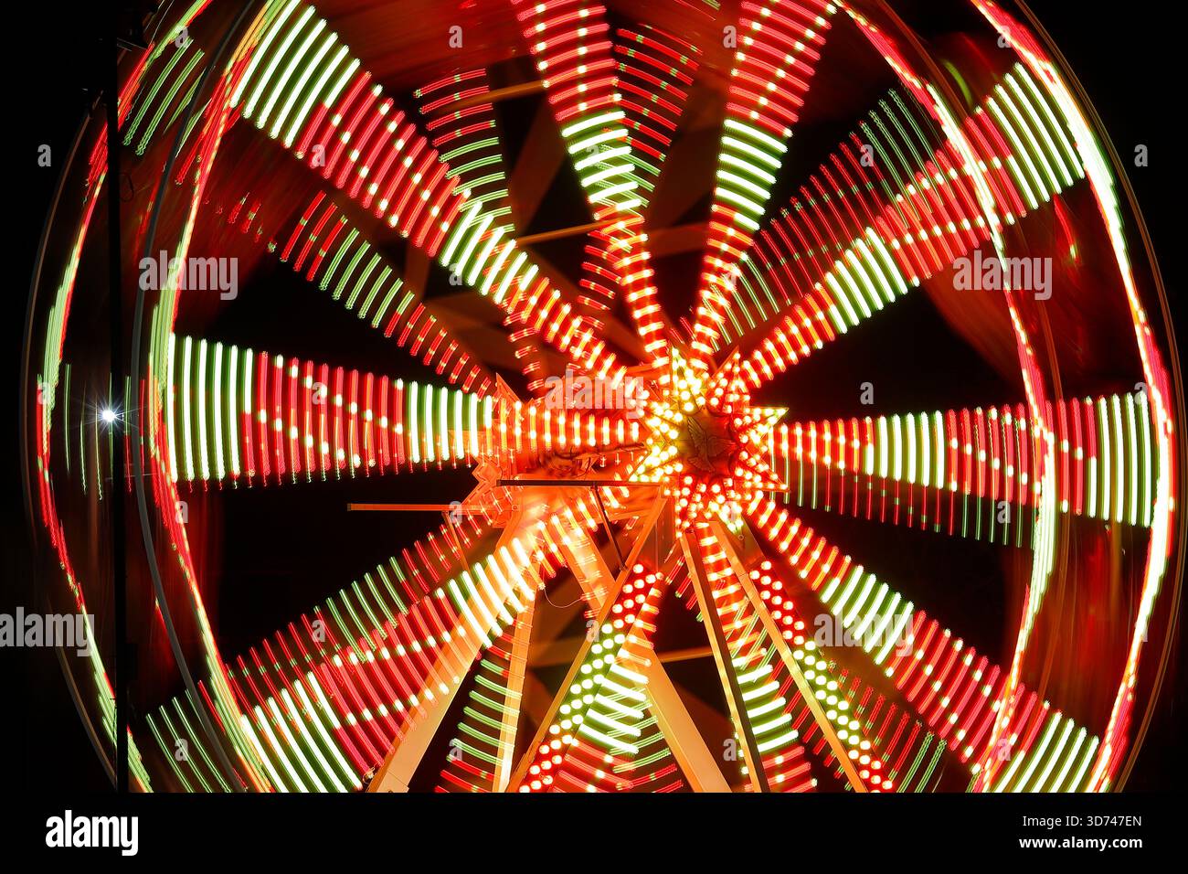 Lunga esposizione di una ruota panoramica illuminata di notte durante l'evento dell'aurora boreale al Temple Newsam di Leeds, West Yorkshire, Regno Unito Foto Stock