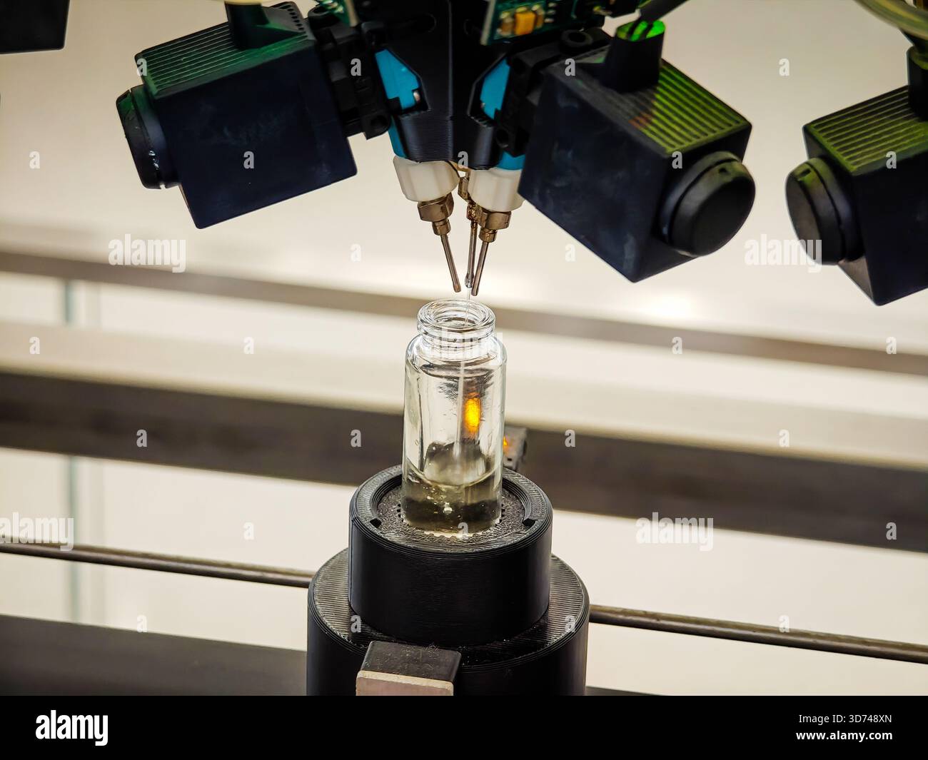 Produzione di profumi. Profumi diversi in bottiglia. Linea di produzione robotizzata di profumi con erogazione automatica di fragranze Foto Stock