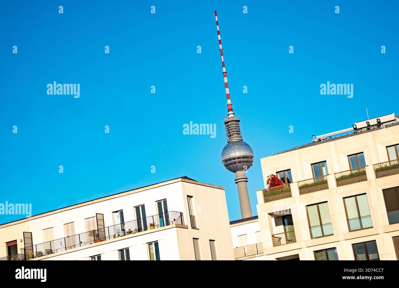 Berlino, Germania – gli appartamenti moderni incorniciano la torre della televisione contro un cielo blu brillante. Foto Stock
