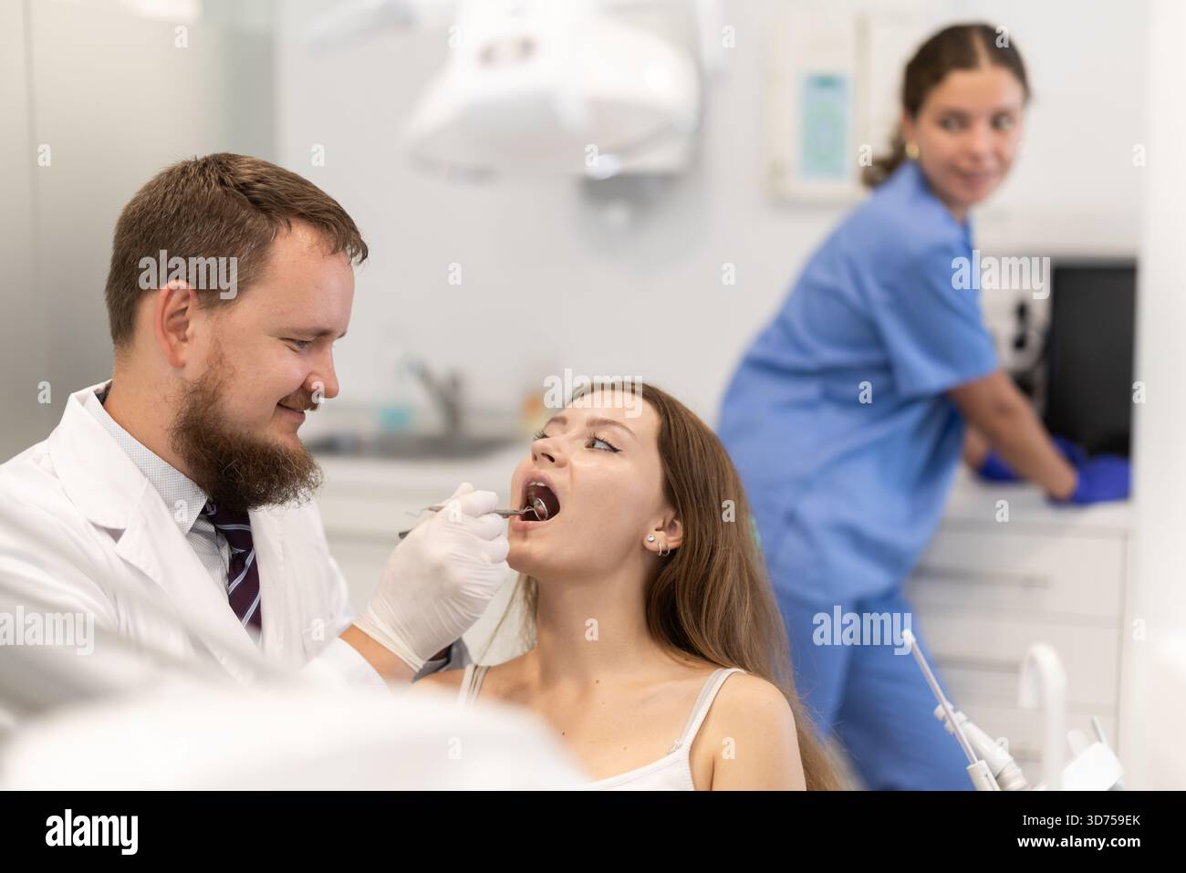 Donna che controlla i denti ad un appuntamento dal dentista Foto Stock