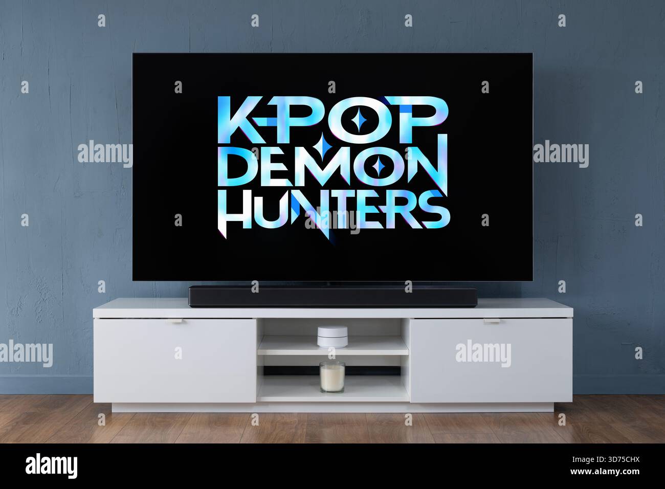 Un televisore OLED widescreen che mostra il logo della serie TV di Netflix K-Pop Demon Hunters visto in un salotto contemporaneo. Foto Stock