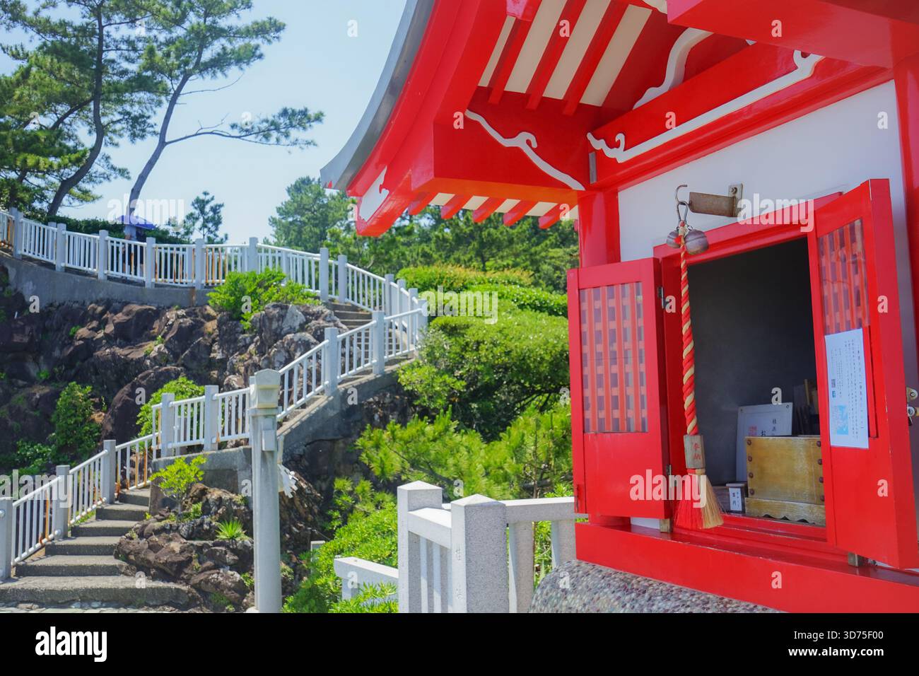 Santuario rosso brillante e scala dietro al santuario Kaizumi Jinja (Watatsumi Jinja), un santuario shintoista sul lato dell'oceano sulla spiaggia di Katsurahama a Kochi, Giappone Foto Stock