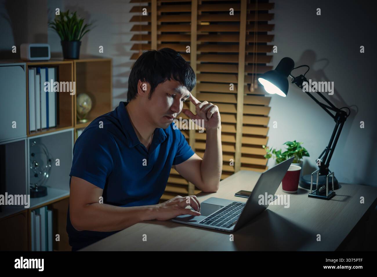 uomo che pensa e lavora con un notebook di notte Foto Stock