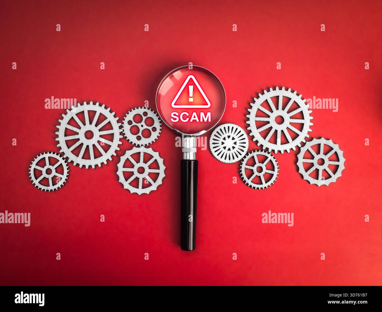 Concetto di allarme truffa con lente di ingrandimento che evidenzia il segnale di avvertimento tra gli ingranaggi meccanici in rosso, simboleggia il rilevamento delle frodi e la prevenzione delle minacce informatiche Foto Stock
