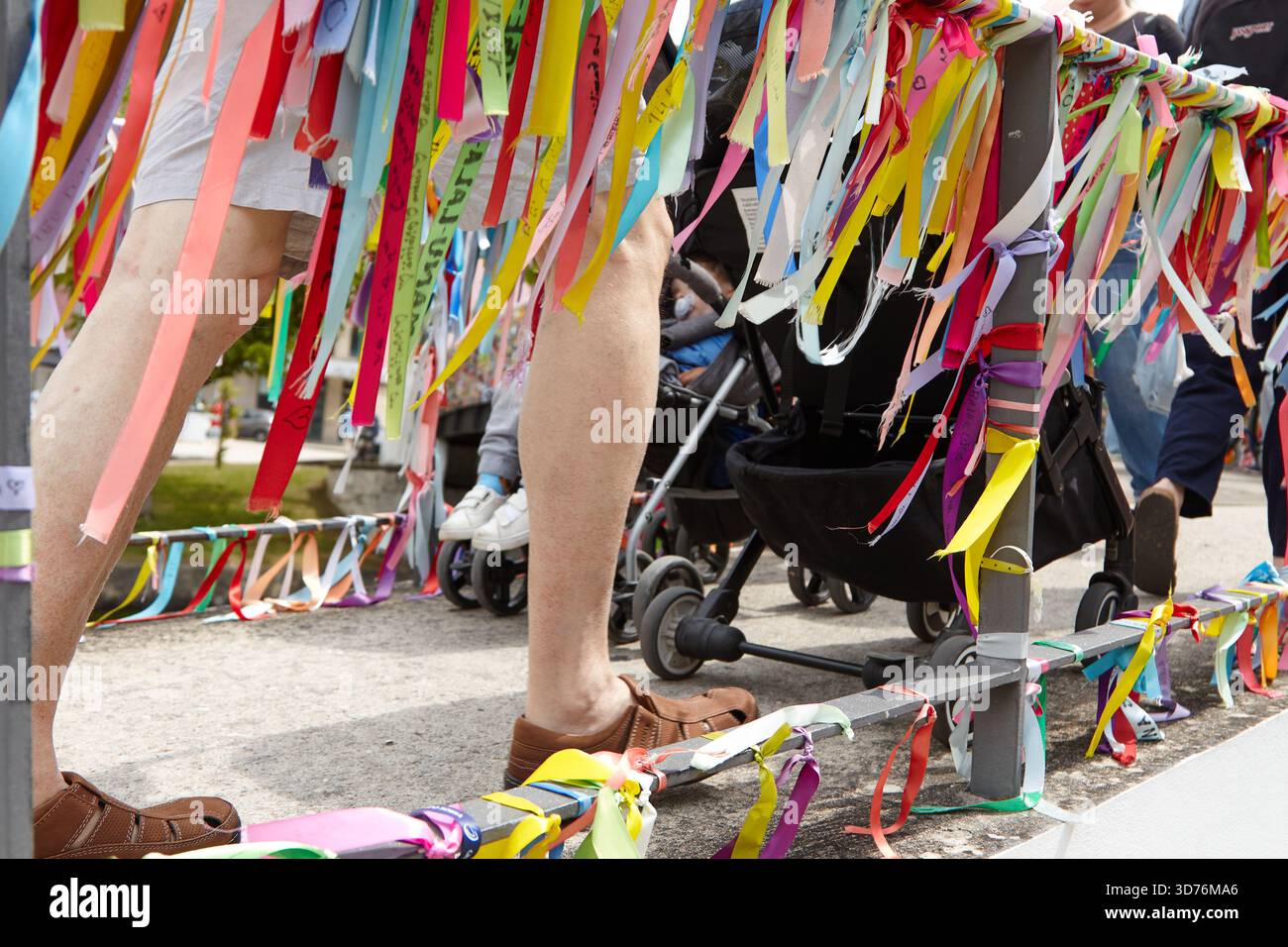 Vivaci nastri legati a un ponte su un canale, che creano una scena vivace piena di colori e simbolismo, invitando i visitatori a condividere i loro desideri e il dr Foto Stock