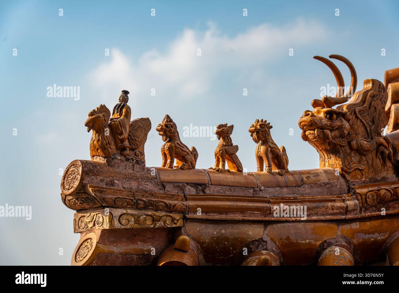 Un estremo primo piano di statuette sul tetto in ceramica smaltata (guardie imperiali e bestie mitiche) in un tradizionale edificio cinese. Le cifre si distinguono per ag Foto Stock