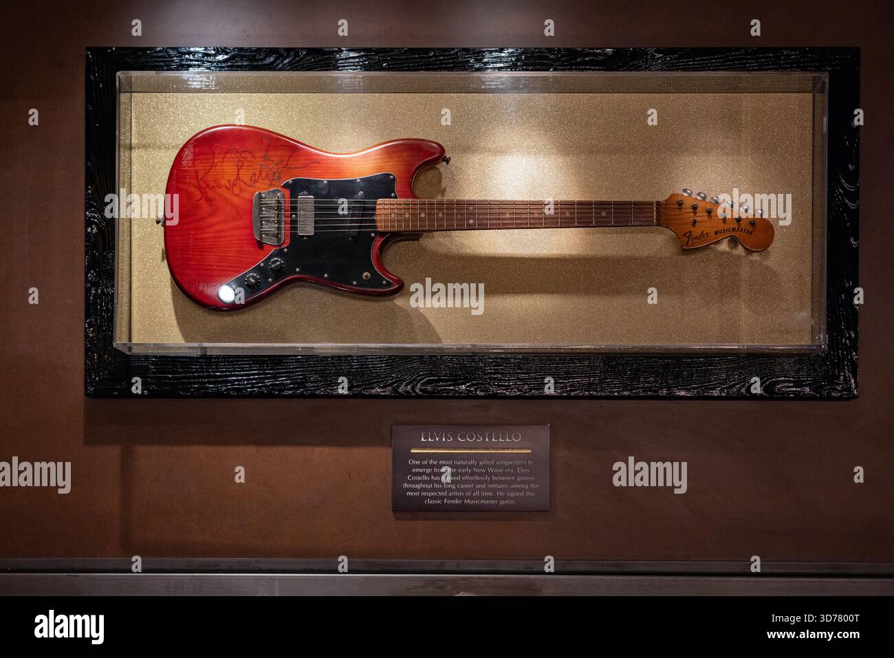 Una chitarra Fender Musicmaster, firmata da Elvis Costello in mostra all'Hard Rock Cafe di Londra Piccadilly. Foto Stock