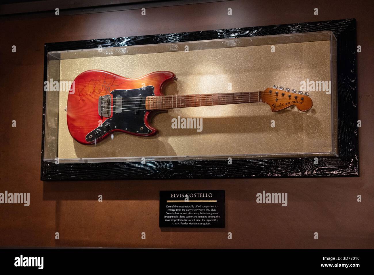 Una chitarra Fender Musicmaster, firmata da Elvis Costello in mostra all'Hard Rock Cafe di Londra Piccadilly. Foto Stock