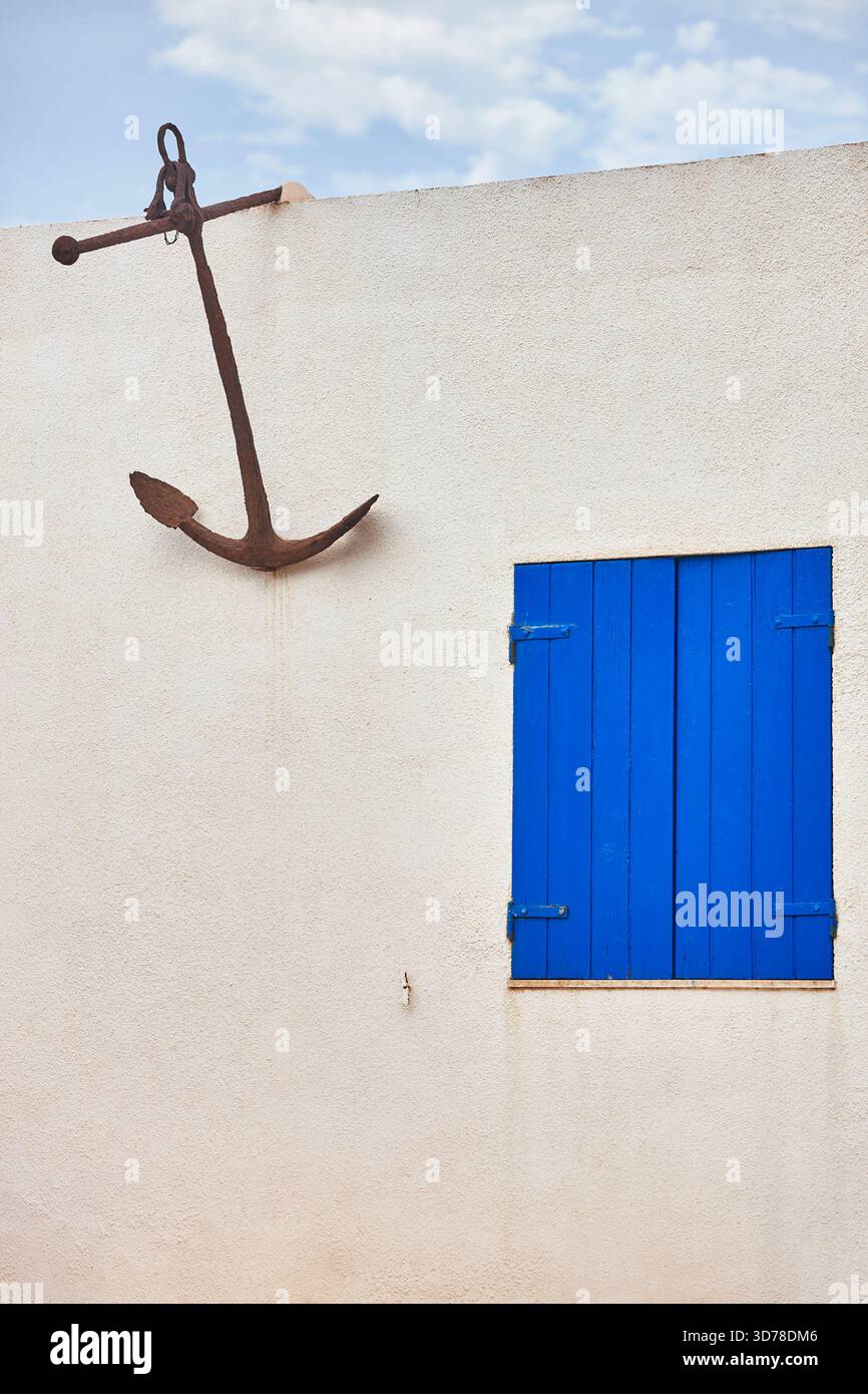 Edificio bianco con facciata di stile mediterraneo. Ancoraggio decorativo arrugginito. Spagna Foto Stock