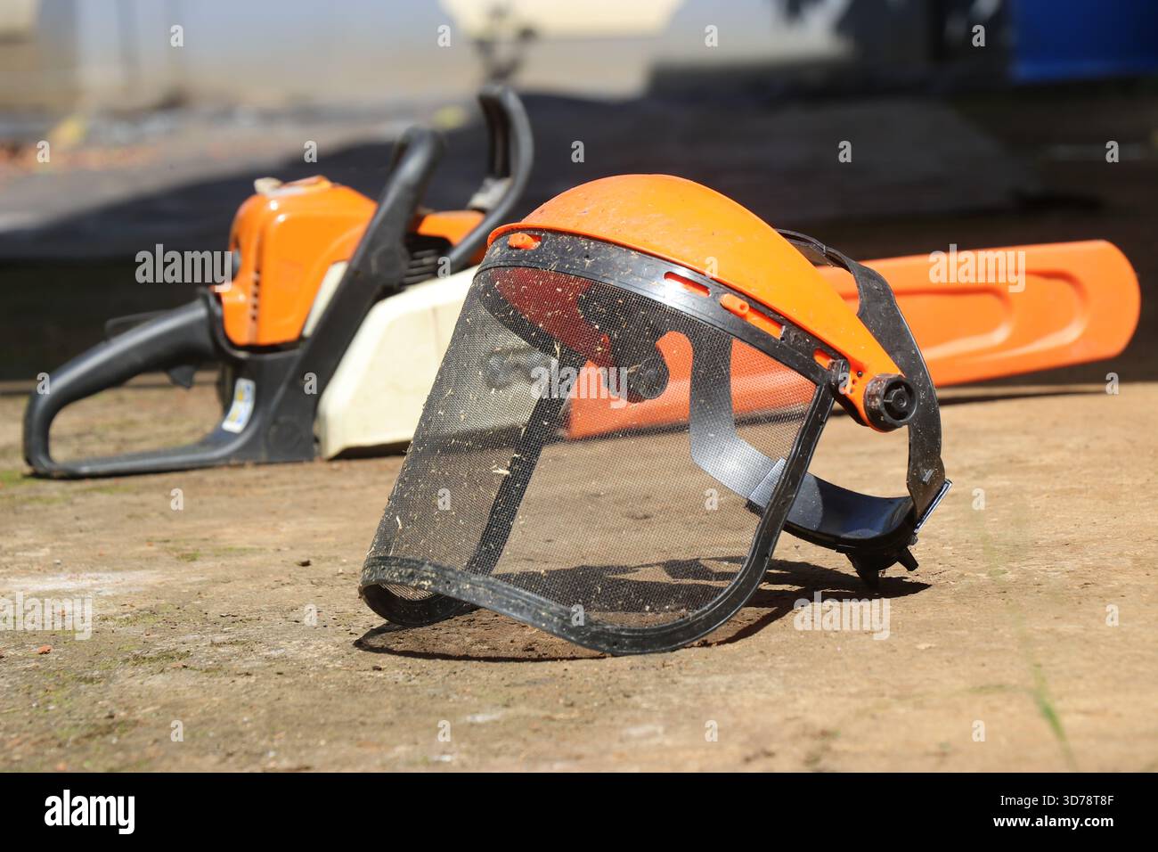 Schermo facciale a rete o rete a faccia intera con motosega sullo sfondo che mostra il concetto di sicurezza Foto Stock