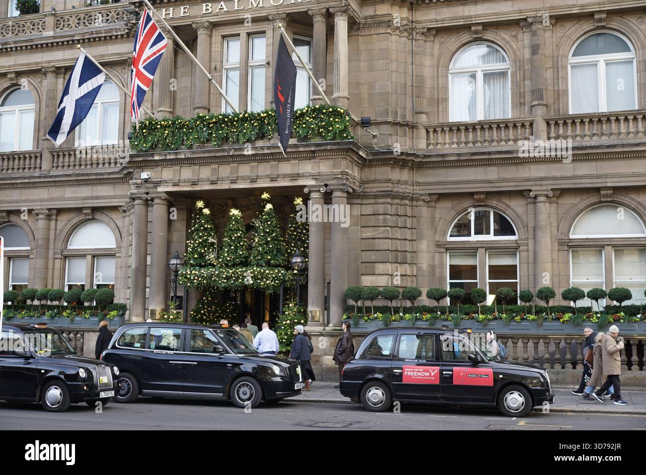 Entrata decorata in modo festoso dell'hotel Balmoral a Edimburgo con taxi neri e pedoni lungo la trafficata strada. Edimburgo, Scozia Foto Stock